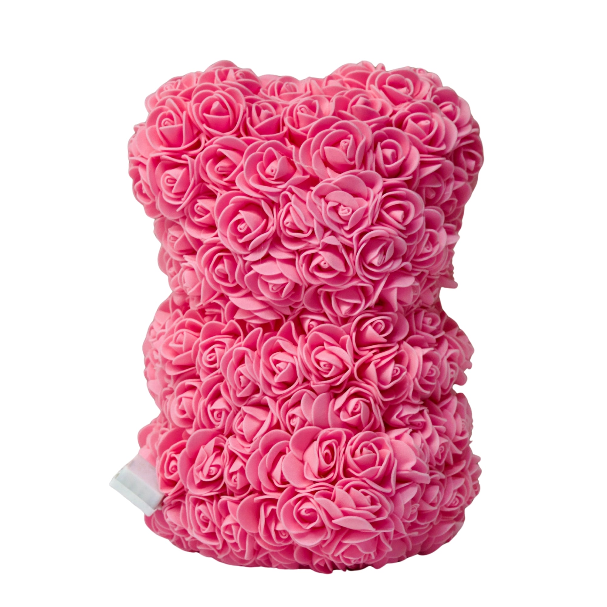 Pink teddy bear-shaped pillow made of rose flowers on a white background