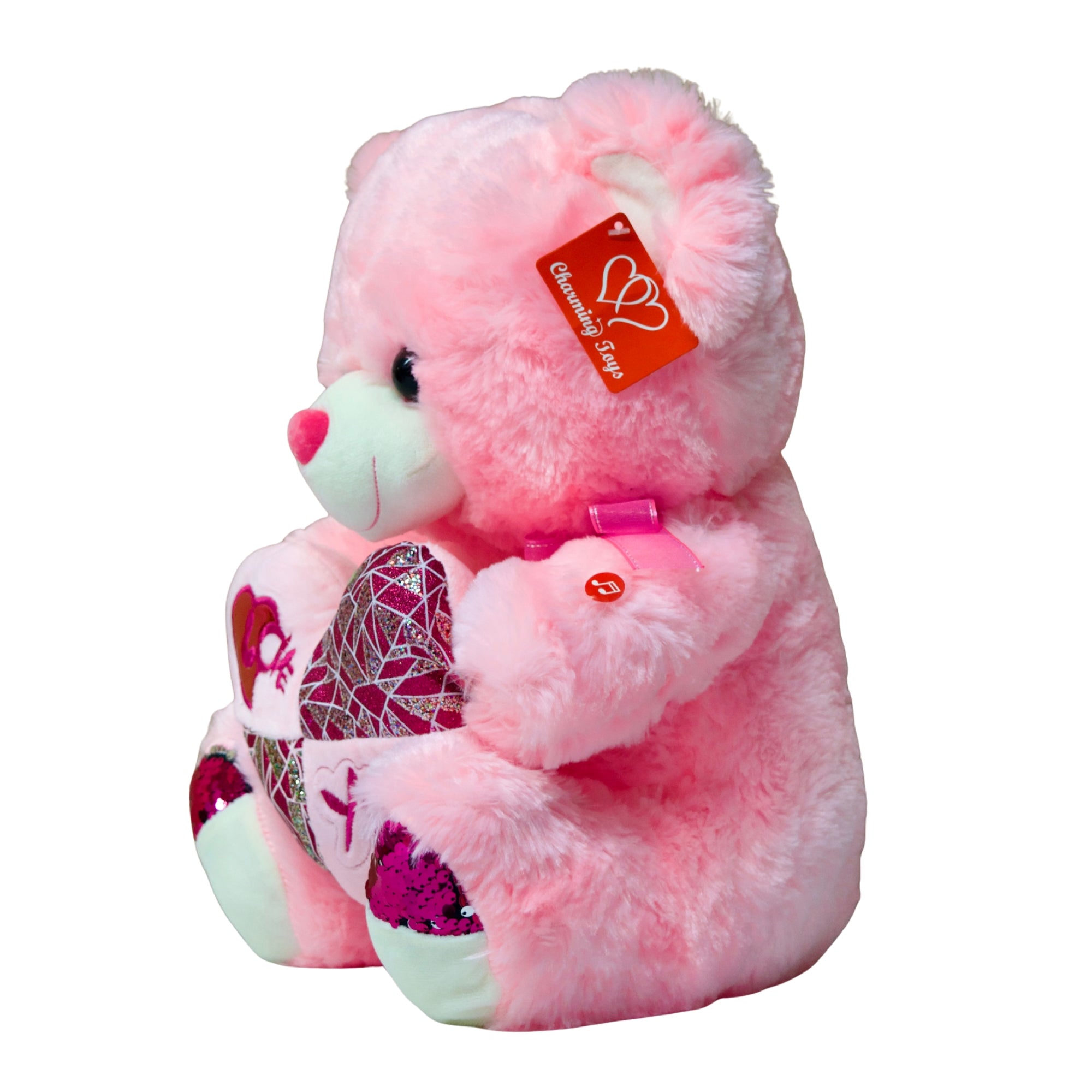 Pink teddy bear with a heart and butterfly design, holding a heart-shaped pillow, on a white background.