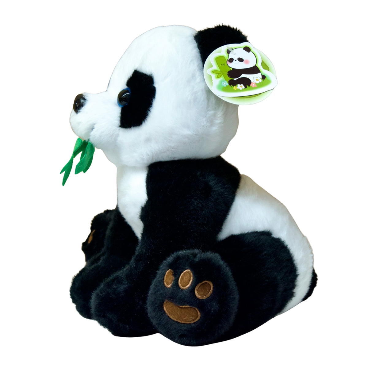 Plush panda toy holding a leaf on a white background